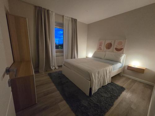 a bedroom with a white bed and a window at Travel Baiot'S in Villanova di Farra