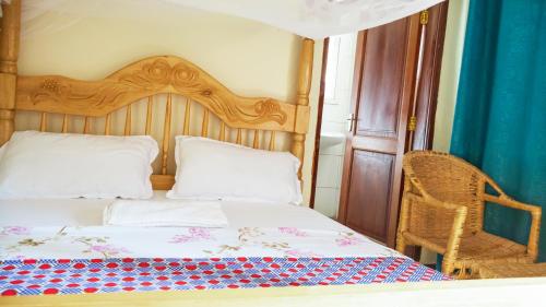 a bedroom with a bed with a wooden headboard at SuPas Bistro in Kisoro
