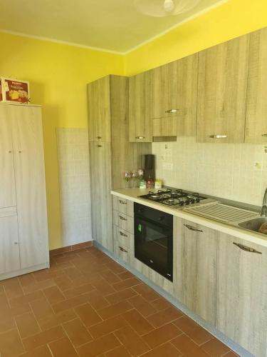 a kitchen with wooden cabinets and a stove top oven at Casa vacanze a Roccella Jonica in Roccella Ionica