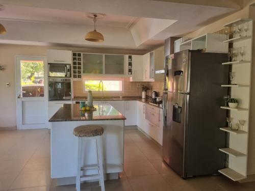 a kitchen with a stainless steel refrigerator and a counter at Casa AONIKENK in Villa Dolores