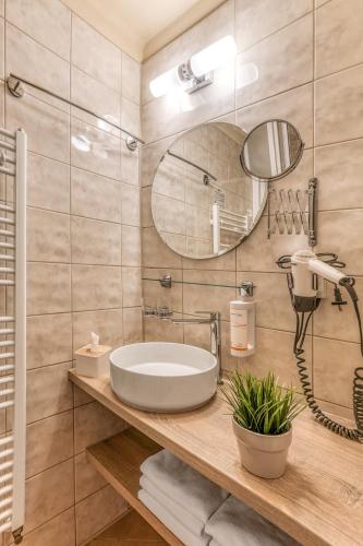 a bathroom with a sink and a mirror at Hotel Slunce - wellness s bazénem, pivovar Morous a bowling in Rýmařov