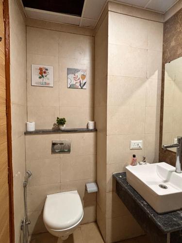 a bathroom with a toilet and a sink at The cozy corner in Ghaziabad