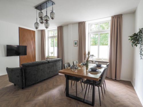 a living room with a table and a couch at Idylle Apartments - Suite Kaisergrün in Bad Ems