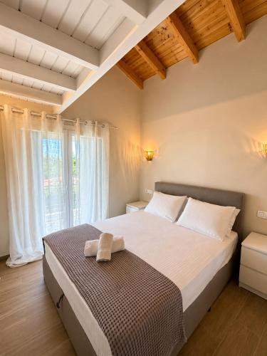 a bedroom with a bed and a large window at Olea Verde Loft Apartment in Lefkimmi