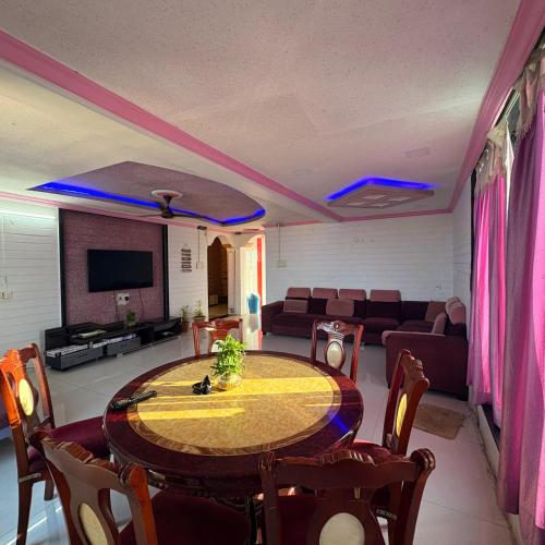 a dining room with a table and a couch at Rooftopwaves penthouse in Daman