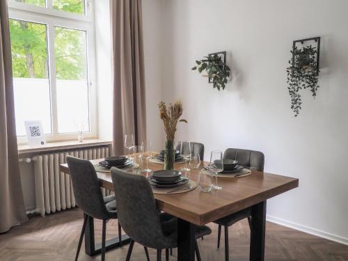 a dining room table with chairs and a wooden table and a window at Idylle Apartments - Suite Kaisergrün in Bad Ems