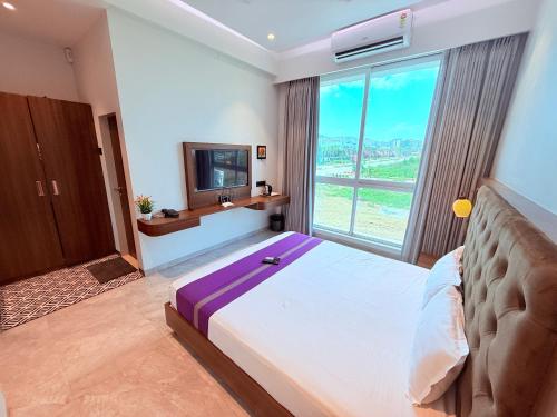 a bedroom with a large bed and a television at Hotel Purple Lotus Suites in Chauk