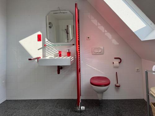a bathroom with a red toilet and a sink at Charming Apartment Stade in Stade