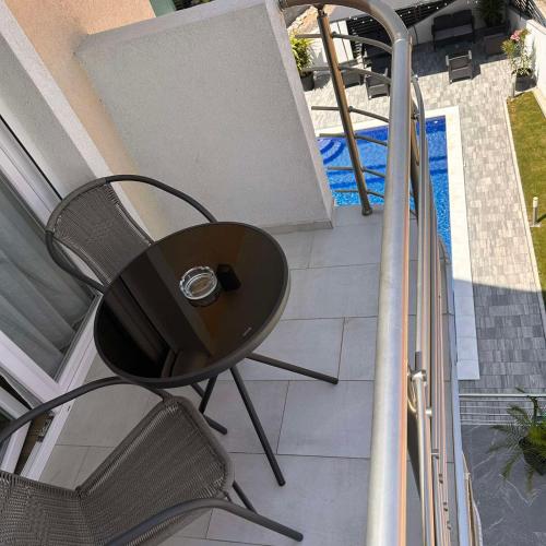 a table and chairs on a balcony with a pool at Villa Ronić in Soko Banja