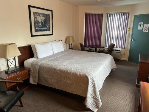a hotel room with a bed and a table and chairs at Lakeview Resort Motel in Wasaga Beach
