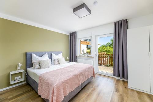 a bedroom with a bed and a large window at Ferienhaus Primavera in Mörsdorf