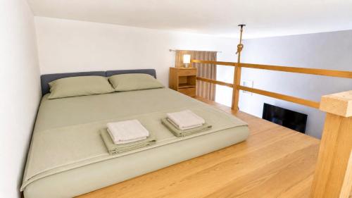 a bedroom with a large bed with two towels on it at Apartmani Vukovic in Budva
