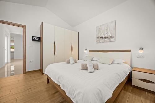 a white bedroom with a large white bed with white pillows at Villa Karla, private pool, 3 bedroom in Divšići