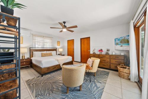 a bedroom with a bed and chairs and a ceiling fan at Moko 159 in Noord