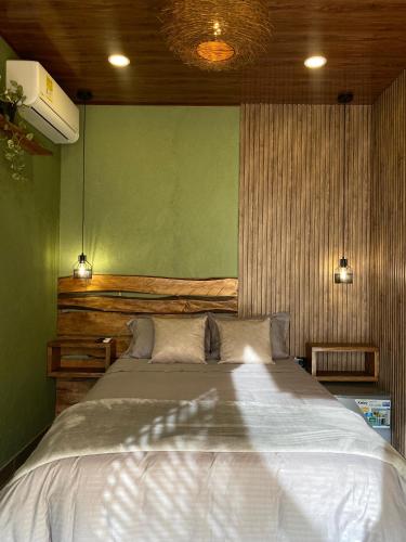 a bedroom with a large bed with a green wall at Palmar el descanso bruma del balsal in Villeta