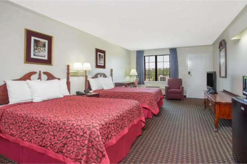 a hotel room with two beds and a television at A Red Dot Inn Milledgeville in Milledgeville
