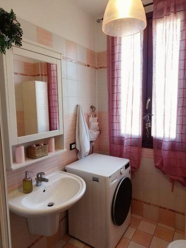 a bathroom with a sink and a washing machine at Pretty home near station & Free Parking in Castel Bolognese
