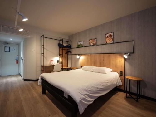 a bedroom with a large white bed in it at Ibis Brive Centre in Brive-la-Gaillarde