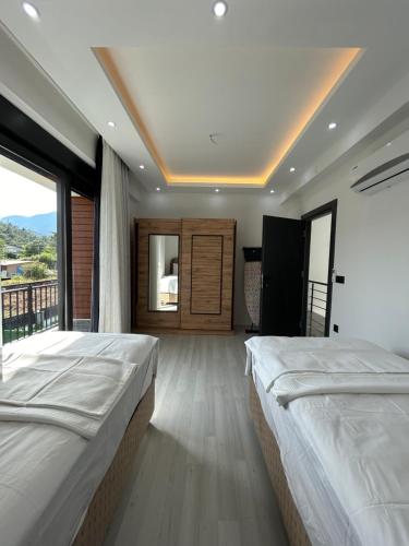 a bedroom with two beds and a large window at Tekirova DOM Villas with Heated Pool in Kemer