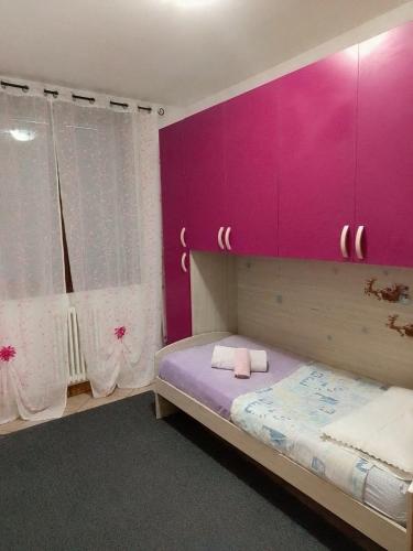 a bedroom with a pink wall and a bed at Pretty home near station & Free Parking in Castel Bolognese