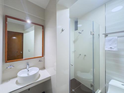 a white bathroom with a sink and a shower at Hotel Yanahuara Suite in Arequipa