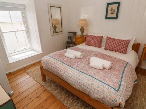 a bedroom with a bed with two pillows on it at Pegs in Porthleven