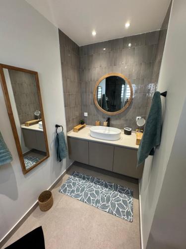 a bathroom with a sink and a mirror at Villa JAUNE in Oyster Pond