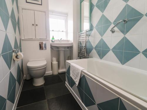 a bathroom with a tub and a toilet and a sink at Pegs in Porthleven