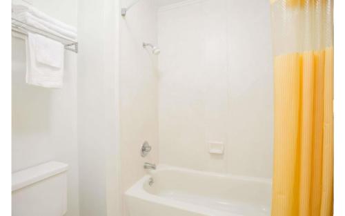 a bathroom with a shower and a tub and a toilet at A Red Dot Inn Milledgeville in Milledgeville