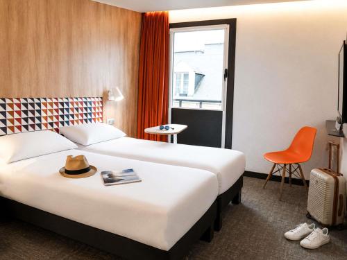 a hotel room with a bed and a chair at ibis Styles Caen Centre Historique in Caen