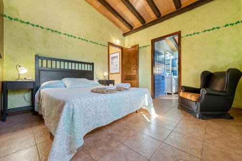a bedroom with a bed and a chair at Masia Puigadoll in Rodonyà