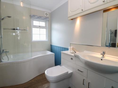 a bathroom with a sink and a toilet and a bath tub at Seaward in Norwich