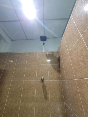 a room with a shower with a tiled floor at Hospedaje céntrico in Zacatecoluca