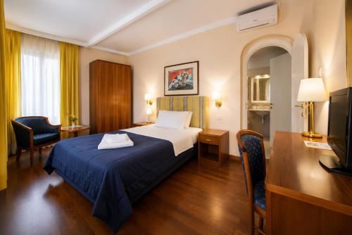 ein Hotelzimmer mit Bett und Fernseher in der Unterkunft Hotel Posta in Cecina