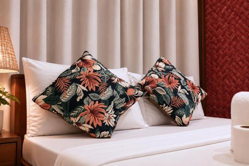 a bed with two pillows on top of it at Jurisu Resort in San Vicente
