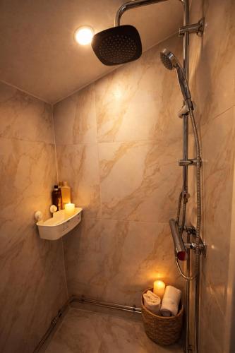 a bathroom with a shower and a sink and candles at Naturstugan in Nacka in Ormingelandet