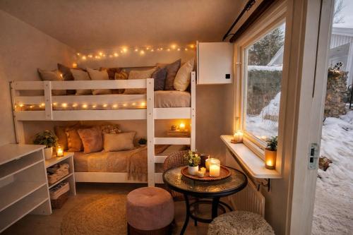 a room with two bunk beds with lights and a table at Naturstugan in Nacka in Ormingelandet