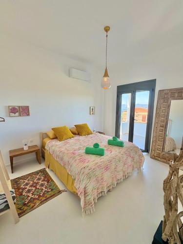 a bedroom with a bed with two green pillows on it at The Izi House in Egina