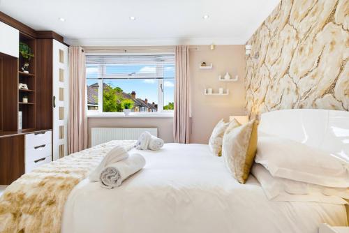 a bedroom with a large white bed with towels on it at Spacious 4BR with Parking for Groups & Contractors in Solihull
