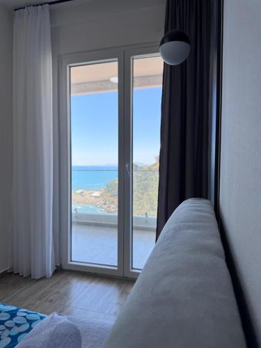 a bedroom with a window with a view of the ocean at Angelo Apartments Ilyonis Residence in Shëngjin