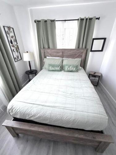 a bedroom with a large bed with a white comforter at Cozy Getaway in Orlando