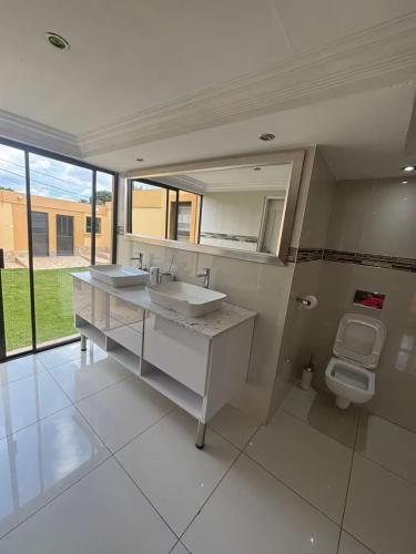 a bathroom with two sinks and a toilet at Monti's Villa Suites in Southgate