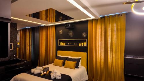 a hotel room with a bed with yellow curtains at L'Écrin d'Or - Spa - Cinéma privé in Saumur