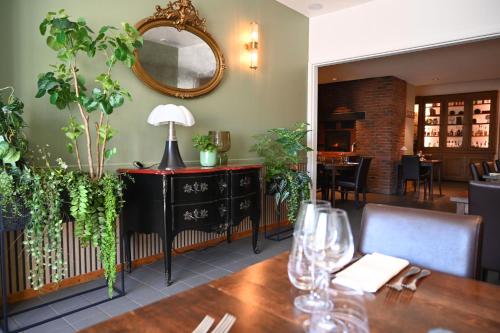 a dining room with a table and a mirror at Au Bon Gîte in Senones