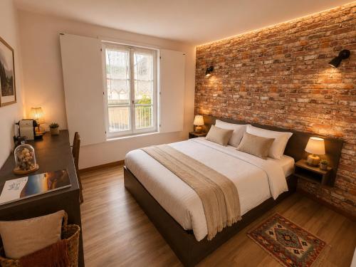 a bedroom with a bed and a brick wall at Au Bon Gîte in Senones