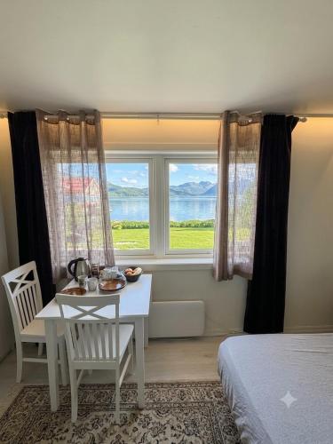 a bedroom with a table and a bed and a window at My Sweet Home in Fauske