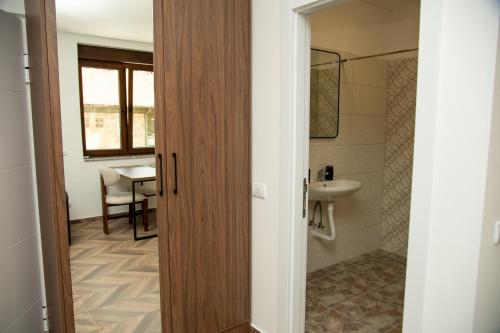 a bathroom with a door leading to a sink at Apartmani Gradska in Prijepolje
