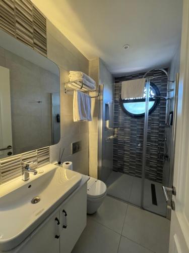 a bathroom with a sink and a toilet and a shower at Cunda EYE in Cunda