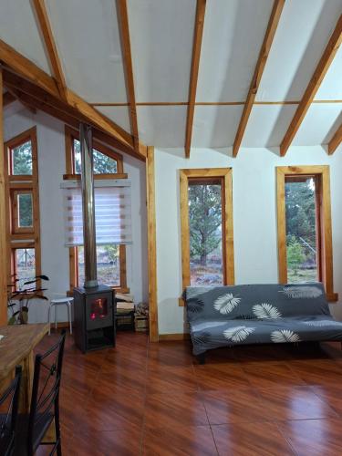 a living room with a couch and a stove at Refugio entre Coihues in Melipeuco