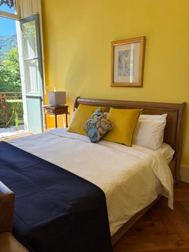 a bedroom with a bed with yellow walls and a window at Chateau de La Lanette in Saléchan
